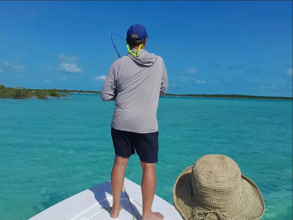 Fly angler casting from a skiff on the Exuma flats