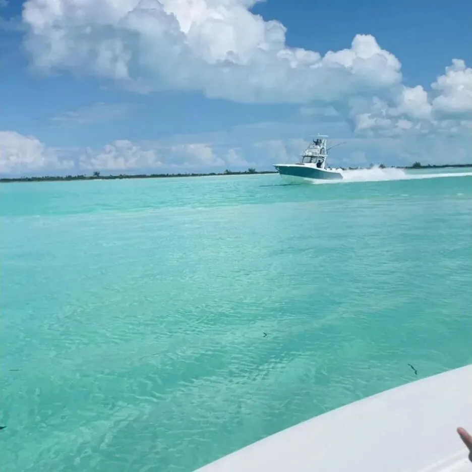 Fishing boat moving across turquoise Exuma water